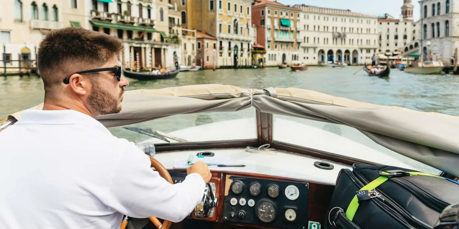 Private water taxi navigating a Venice canal to deliver passengers to their hotel