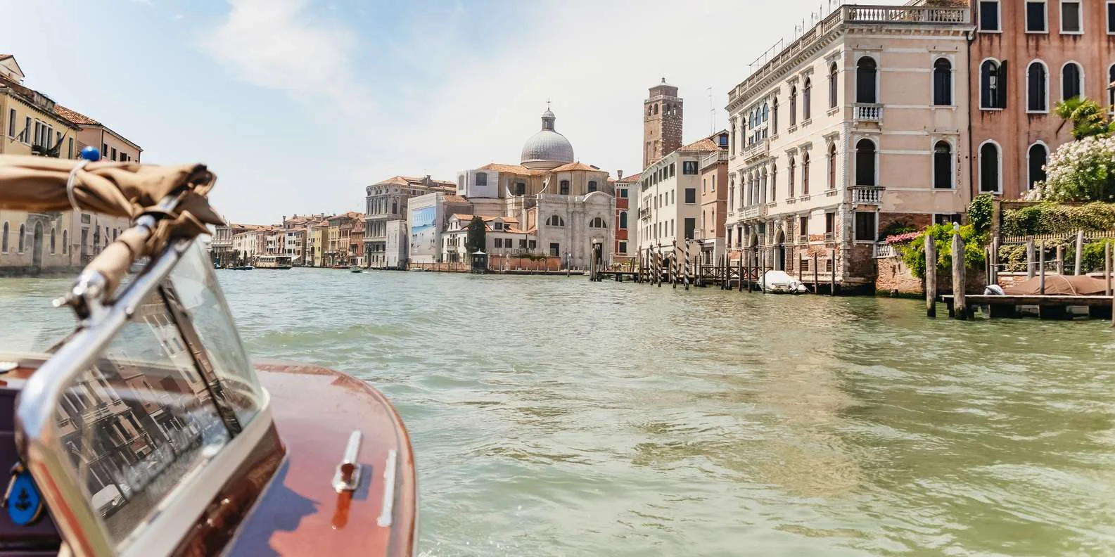 Venice water taxi transfer cruising along the Grand Canal past historic palazzos