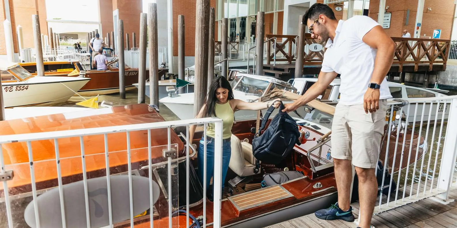 Water taxi arriving at Venice hotel dock to drop off passengers from the airport